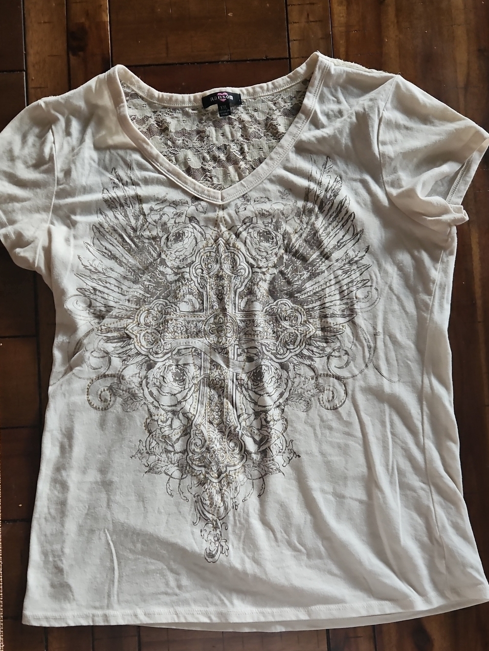 Women's cream colored lace backed T-shirt with graphic on front.